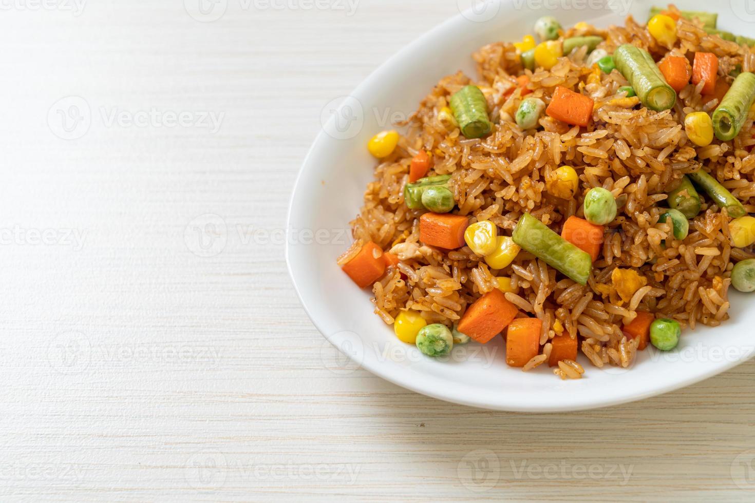 arroz frito com ervilhas, cenouras e milho - estilo de comida vegetariana e saudável foto