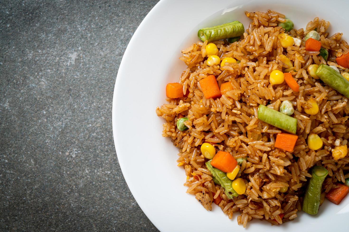 arroz frito com ervilhas, cenouras e milho - estilo de comida vegetariana e saudável foto