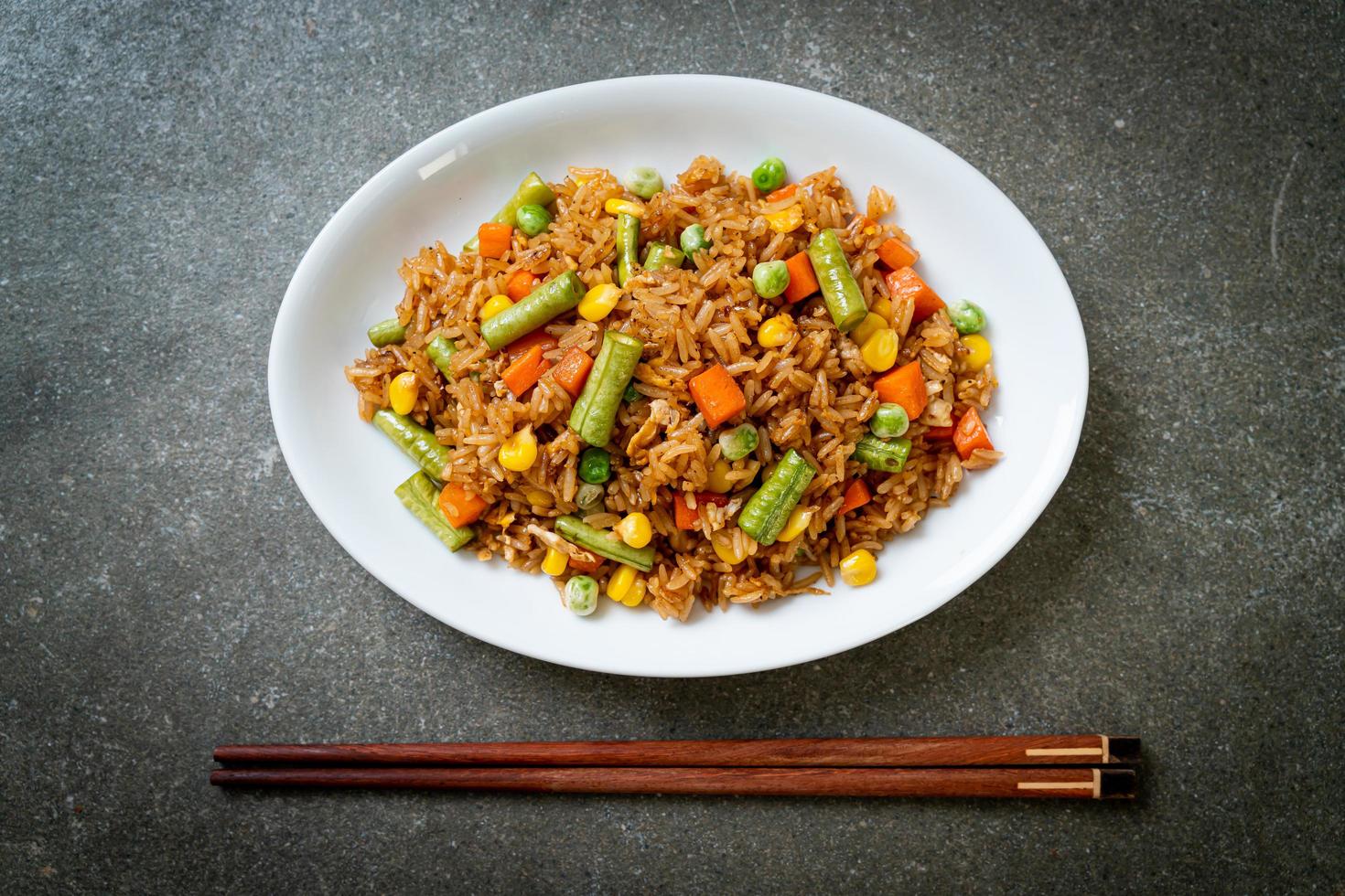 arroz frito com ervilhas, cenouras e milho - estilo de comida vegetariana e saudável foto