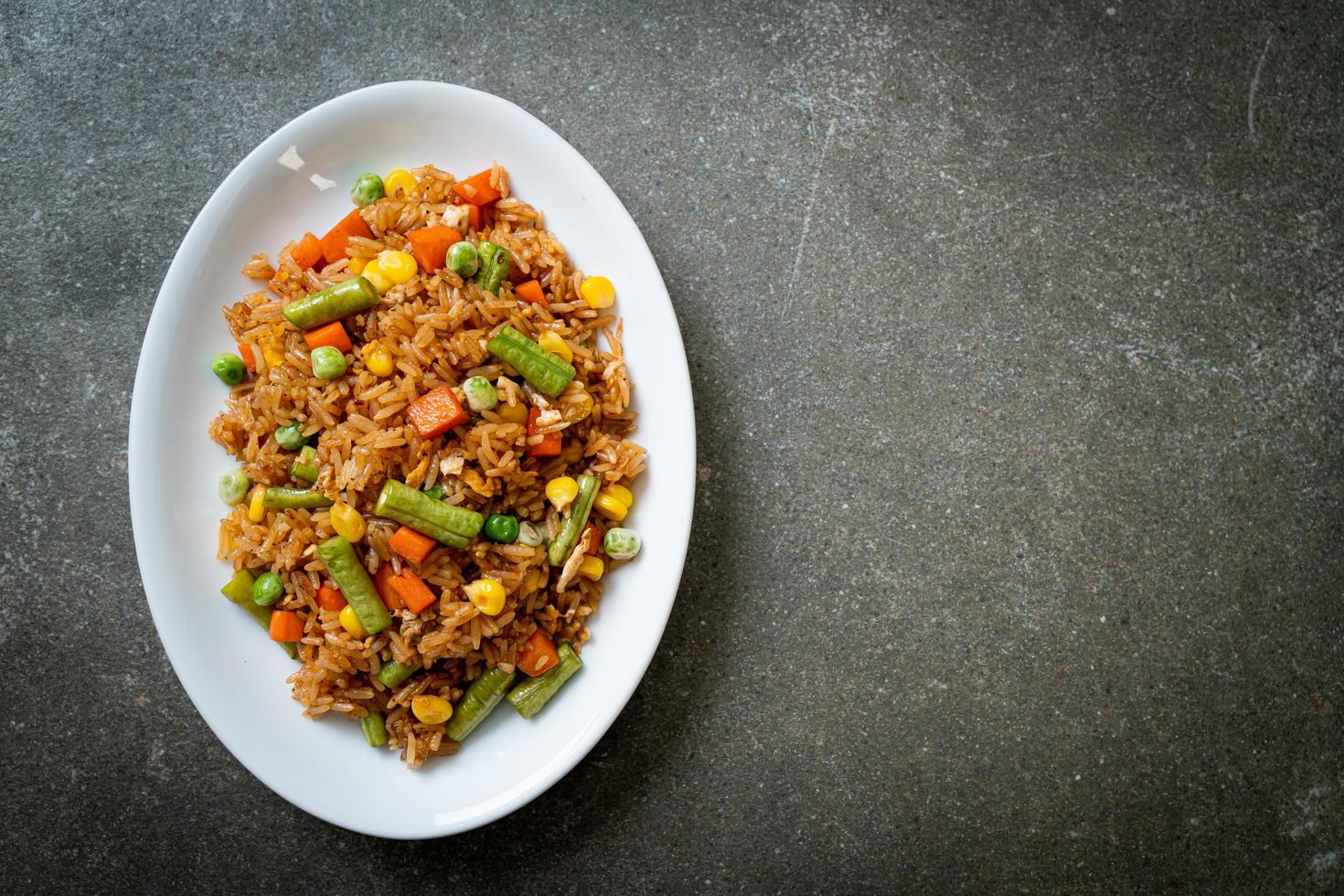 arroz frito com ervilhas, cenouras e milho - estilo de comida vegetariana e saudável foto