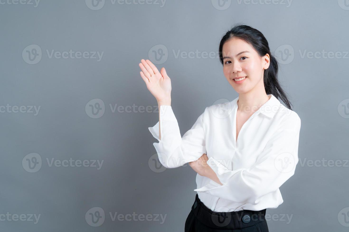 mulher asiática com mão apresentando-se de lado foto