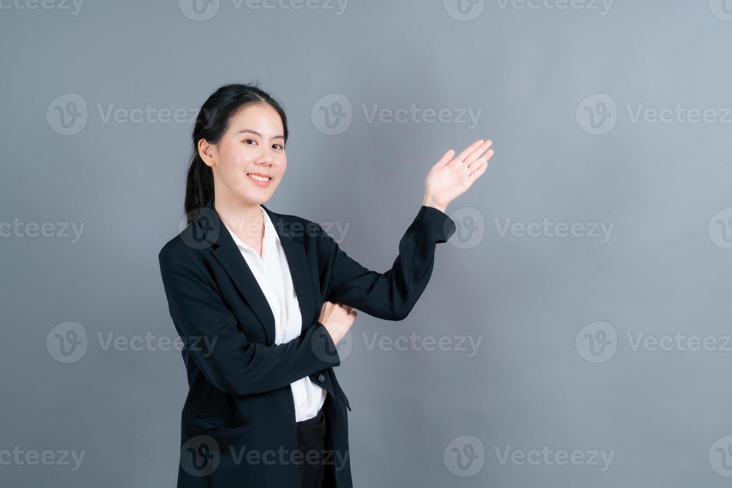 mulher asiática com mão apresentando-se de lado foto