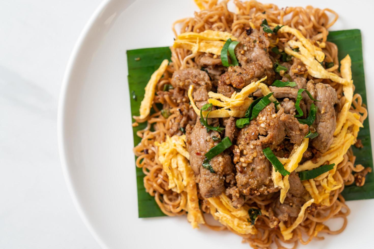 macarrão instantâneo frito com carne de porco e ovo - comida de rua local asiática foto