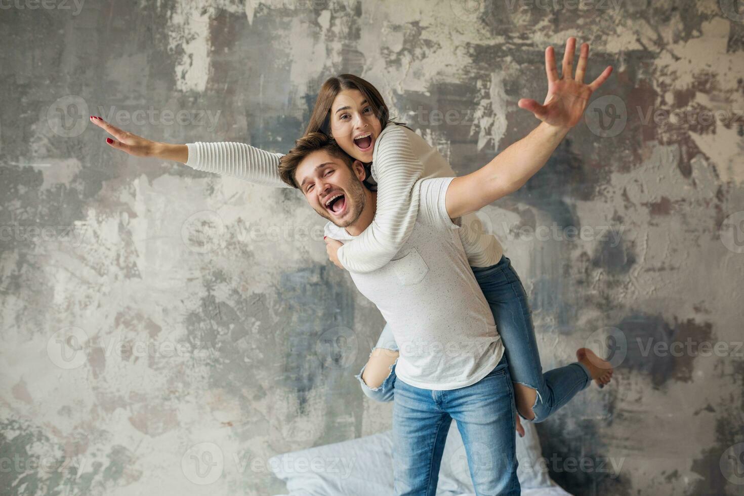 jovem feliz sorridente casal sentado em cama às casa foto