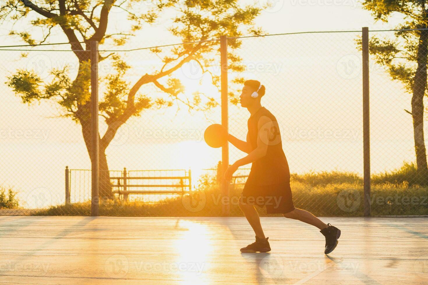 Preto homem fazendo Esportes, jogando basquetebol em nascer do sol, ativo estilo de vida, ensolarado verão manhã foto