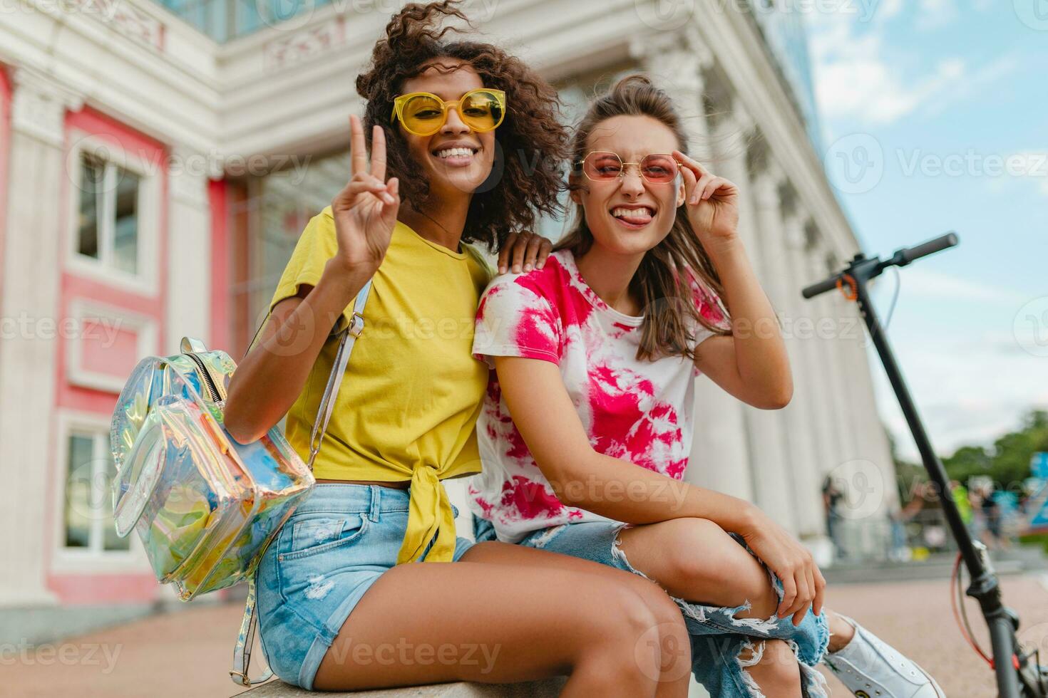 feliz jovem meninas amigos sorridente sentado dentro rua foto