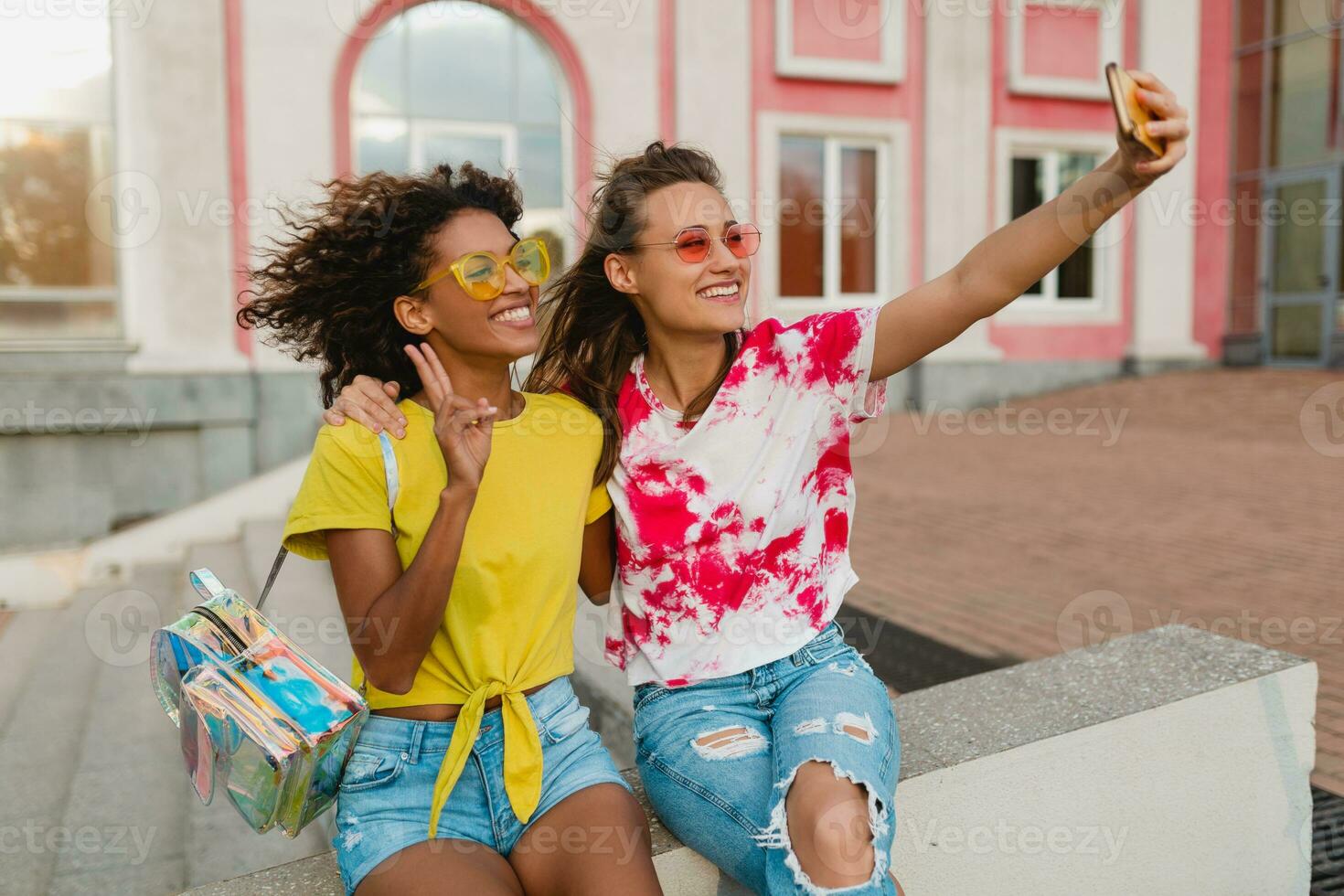 feliz jovem meninas amigos sorridente sentado dentro rua foto