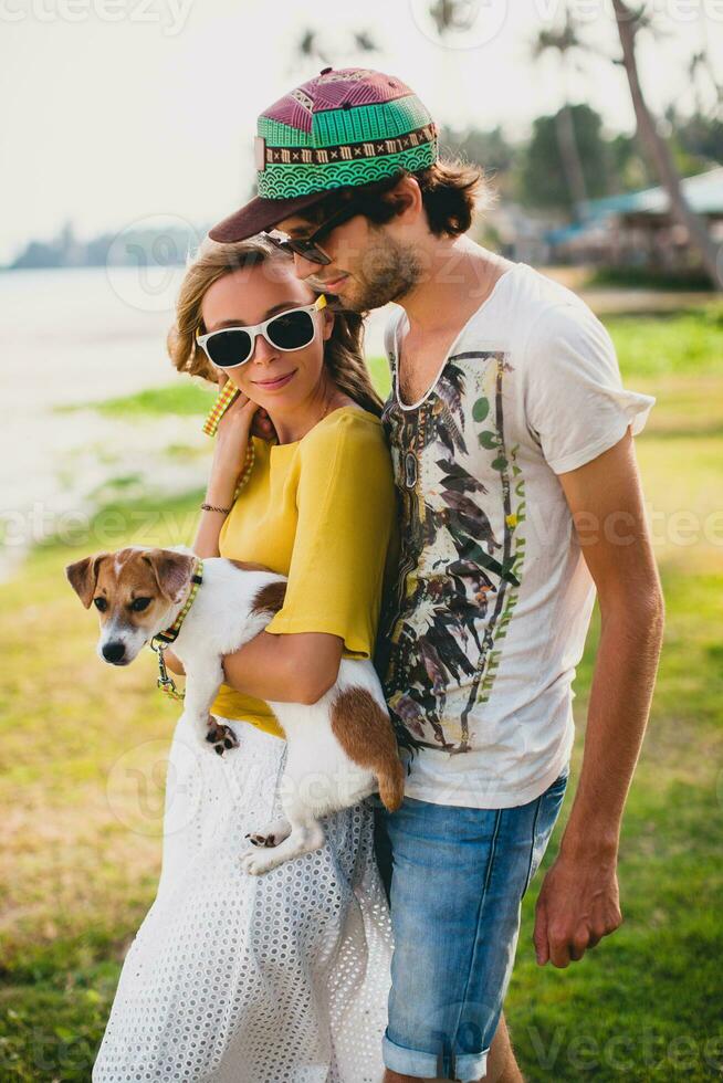 jovem à moda hipster casal dentro amor segurando uma cachorro às a tropical parque foto