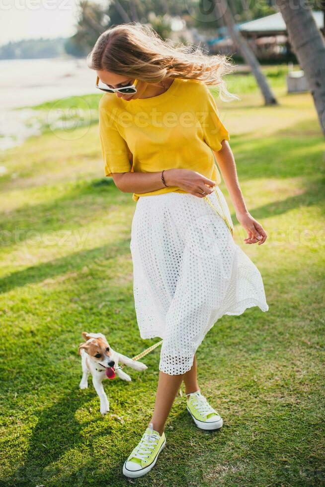 jovem à moda hipster mulher segurando caminhando jogando cachorro cachorro jack russell foto