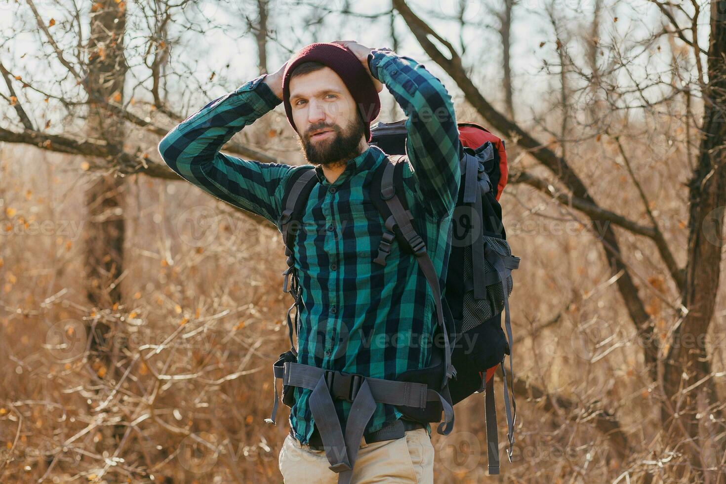 jovem hipster homem viajando com mochila dentro Primavera outono floresta foto