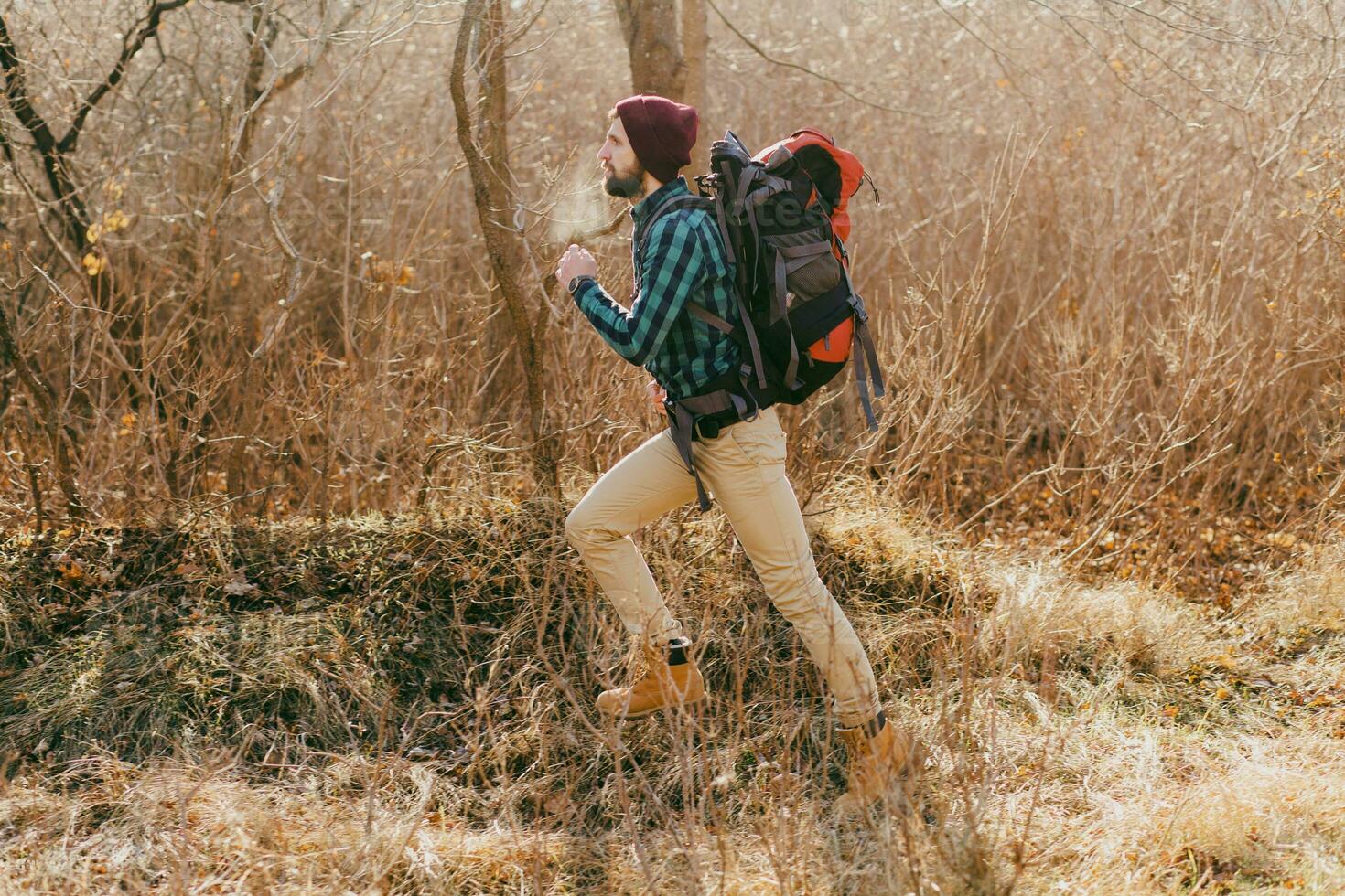 jovem hipster homem viajando com mochila dentro Primavera outono floresta foto