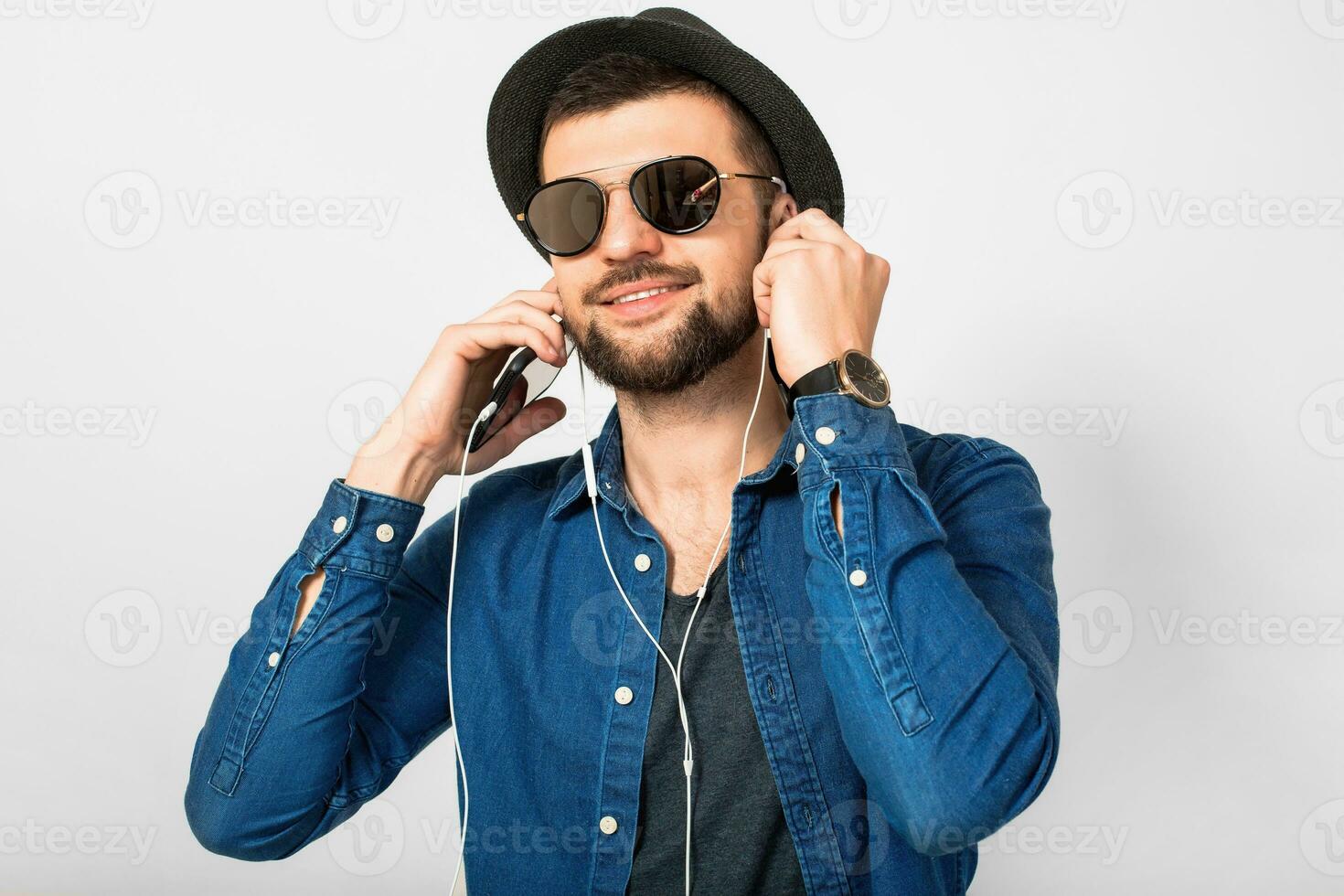 jovem bonito feliz sorridente homem ouvindo para música dentro fones de ouvido foto