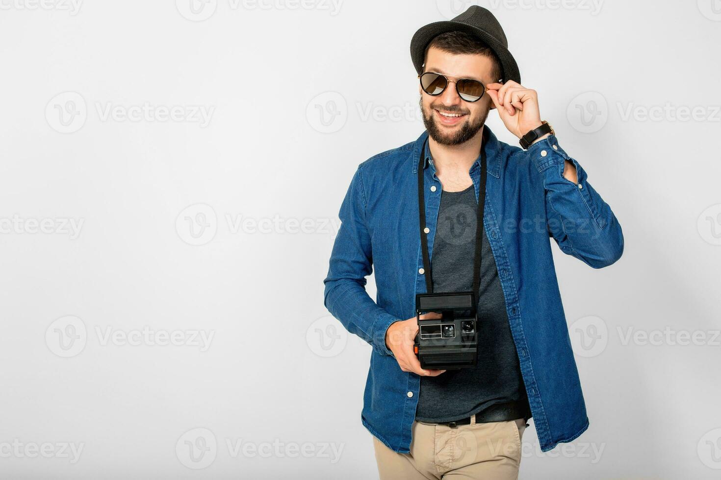 jovem bonito sorridente feliz homem segurando vintage foto Câmera