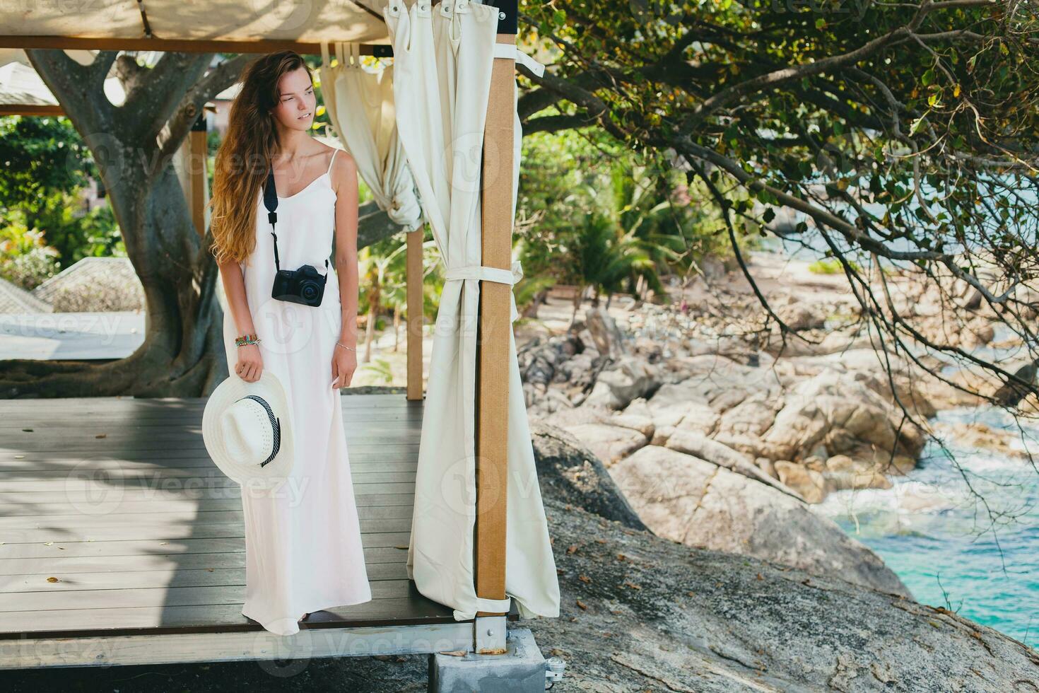 jovem natural lindo mulher dentro pálido vestido, tropical período de férias foto