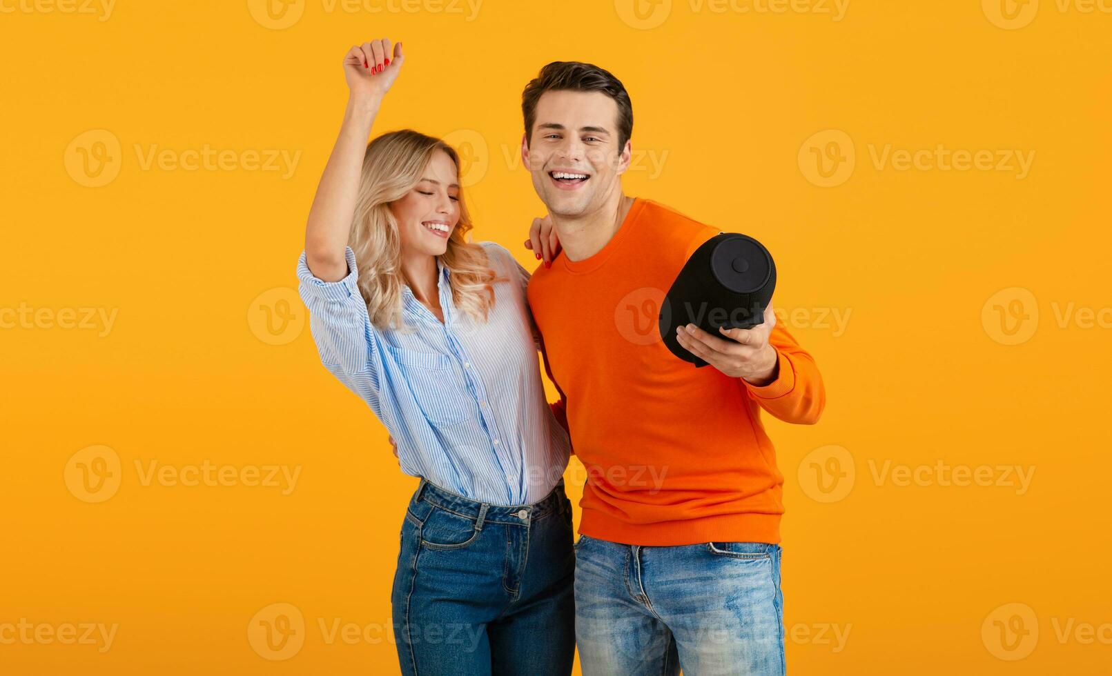atraente à moda jovem casal segurando sem fio alto falante foto