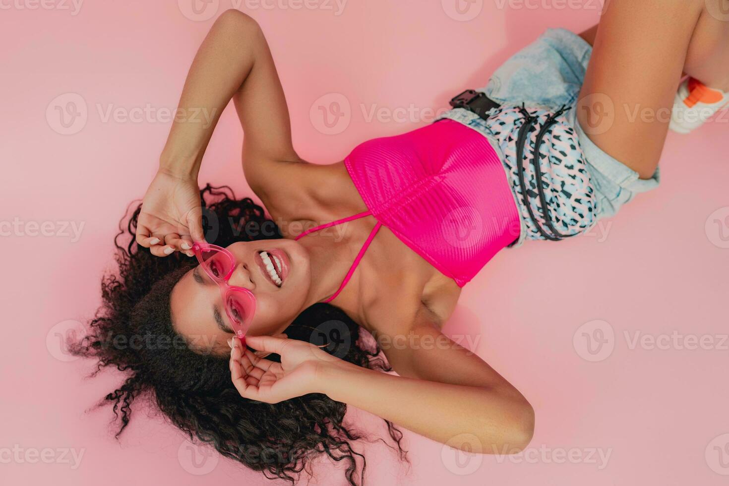 atraente Preto africano americano mulher dentro à moda equipamento em Rosa fundo foto