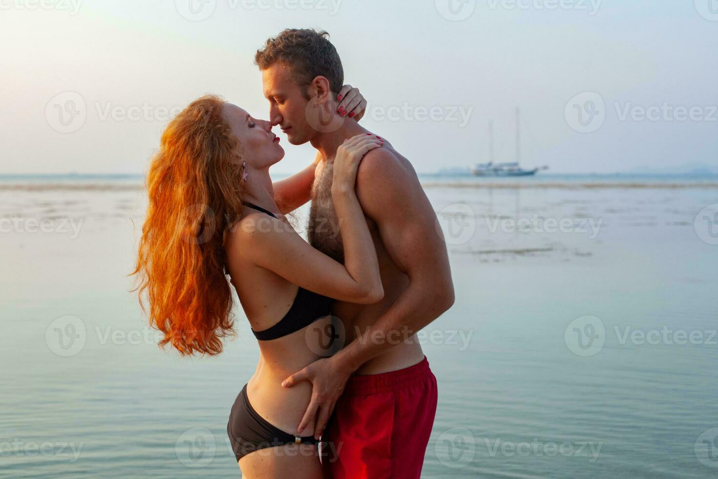 jovem sexy romântico casal dentro amor feliz em verão de praia juntos tendo Diversão vestindo nadar ternos foto