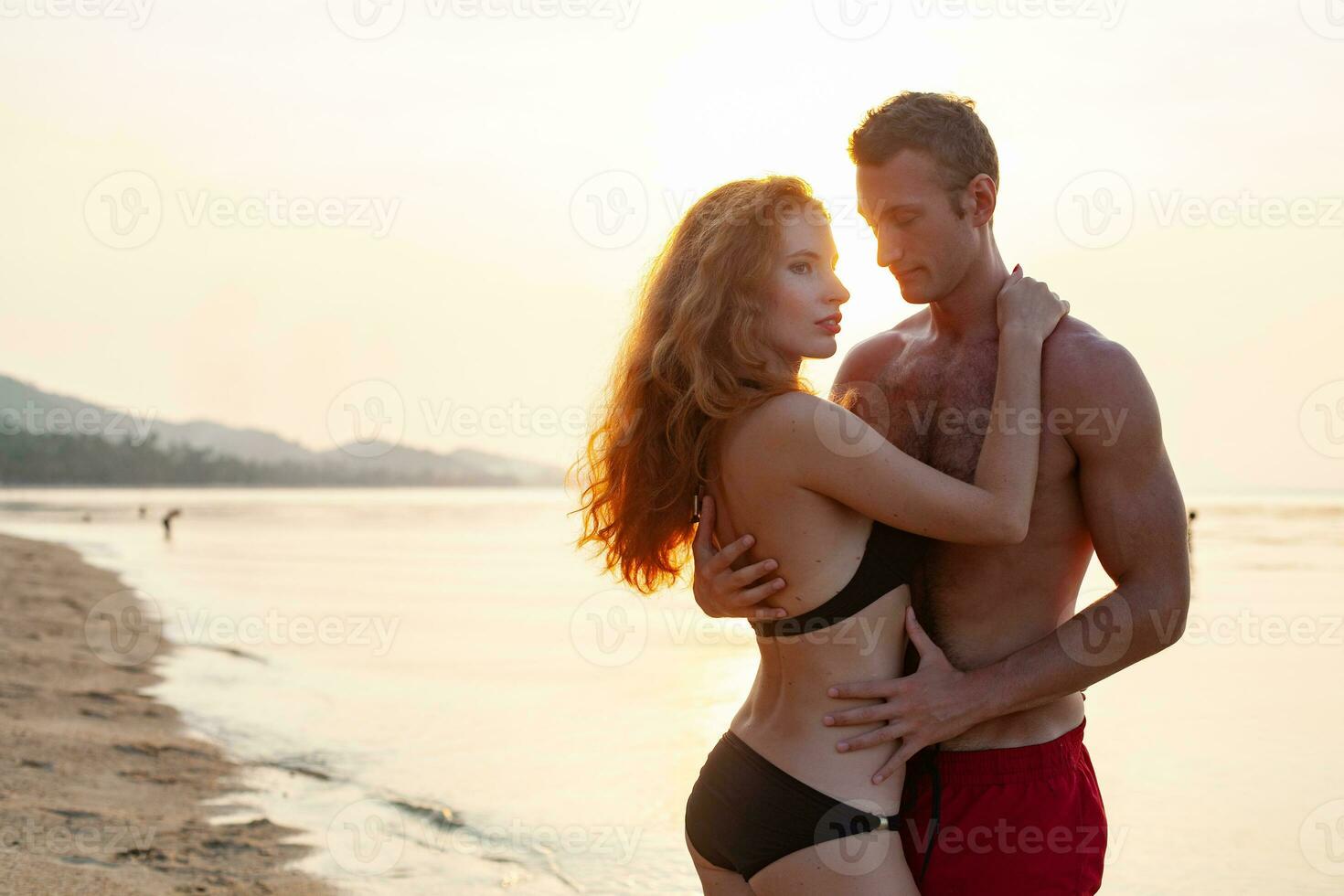 jovem sexy romântico casal dentro amor feliz em verão de praia juntos tendo Diversão vestindo nadar ternos foto