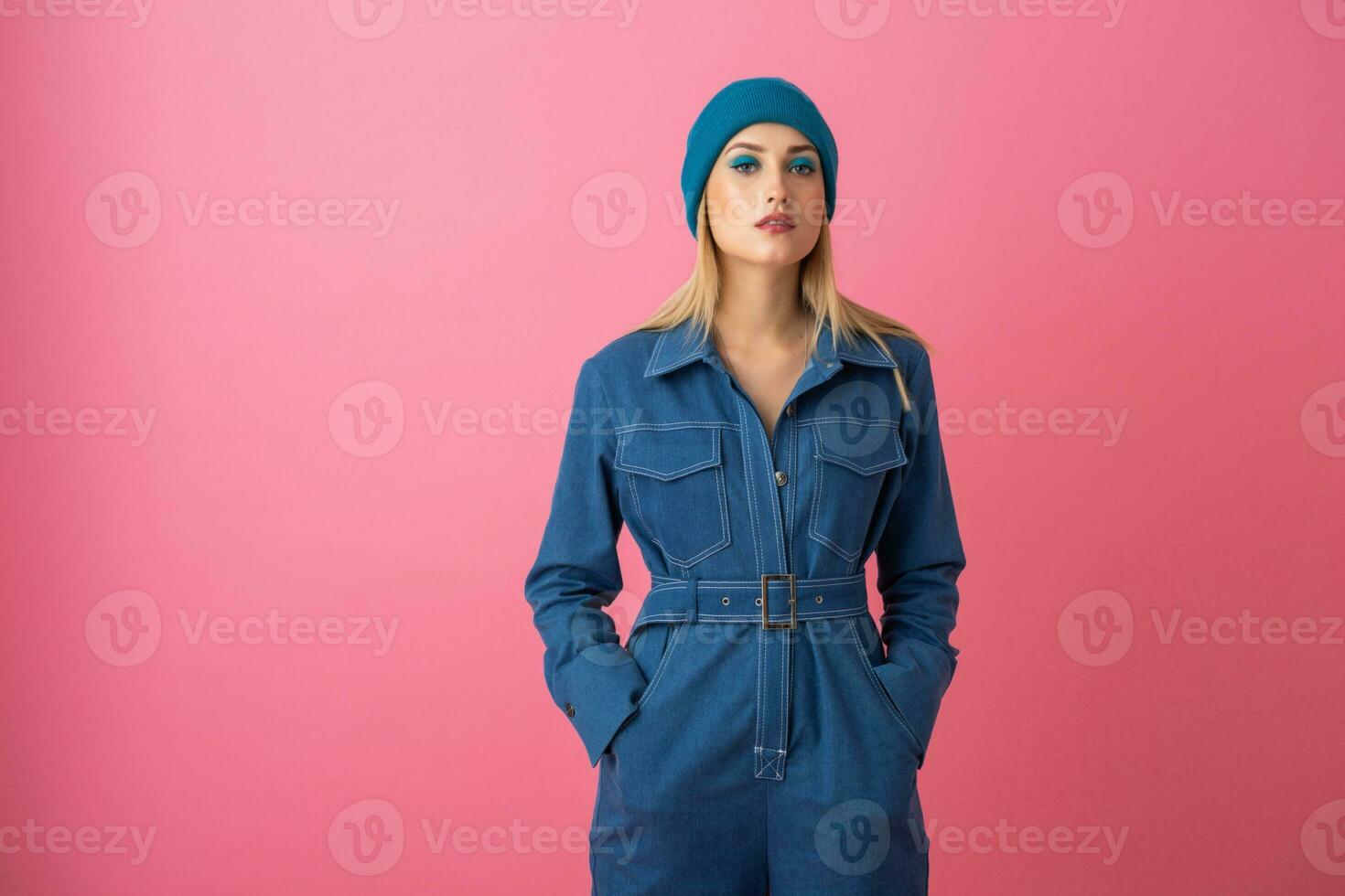 animado atraente menina posando em Rosa fundo dentro jeans No geral moda tendência foto