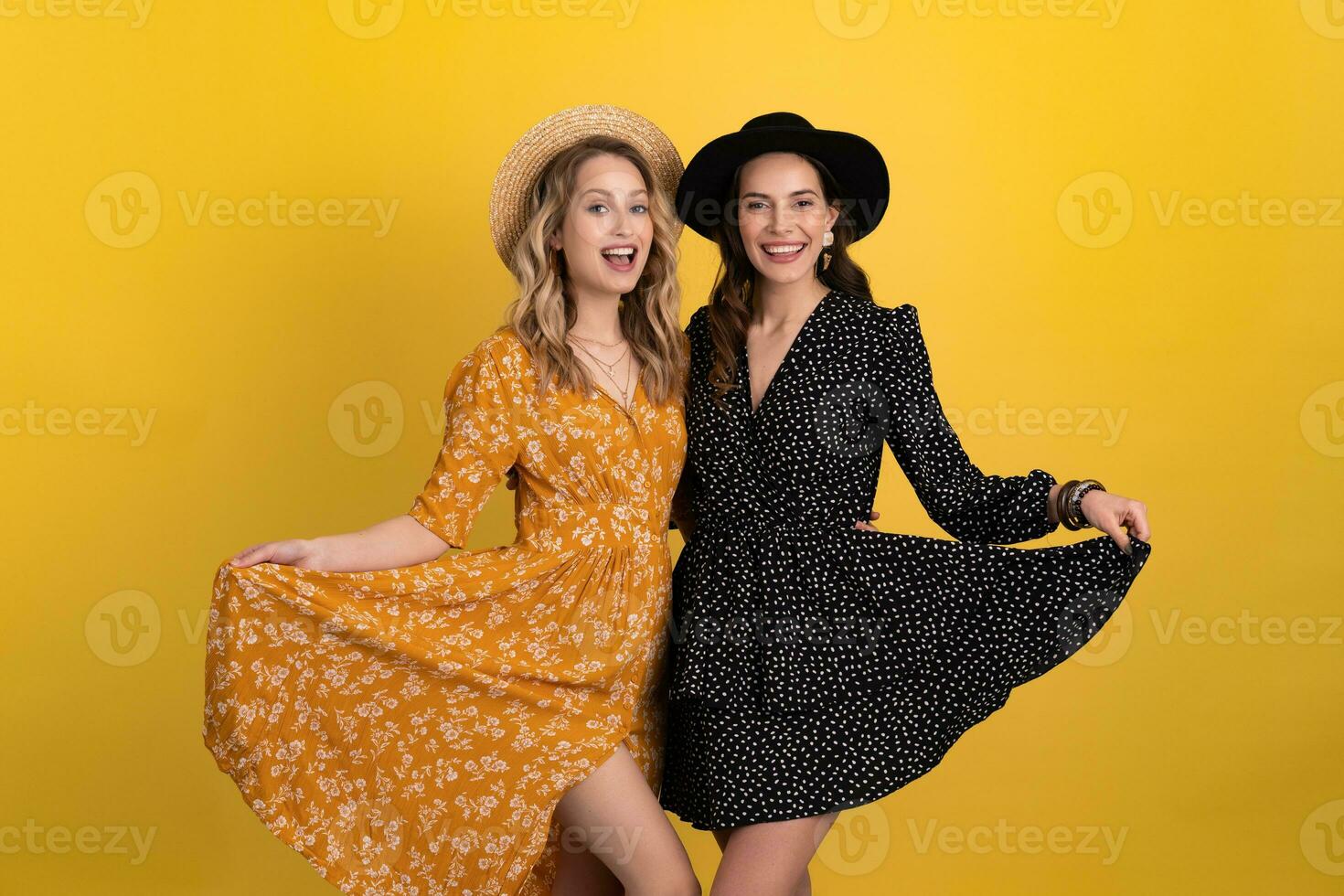 lindo mulheres amigos juntos isolado em amarelo fundo dentro Preto e amarelo vestir e chapéu foto