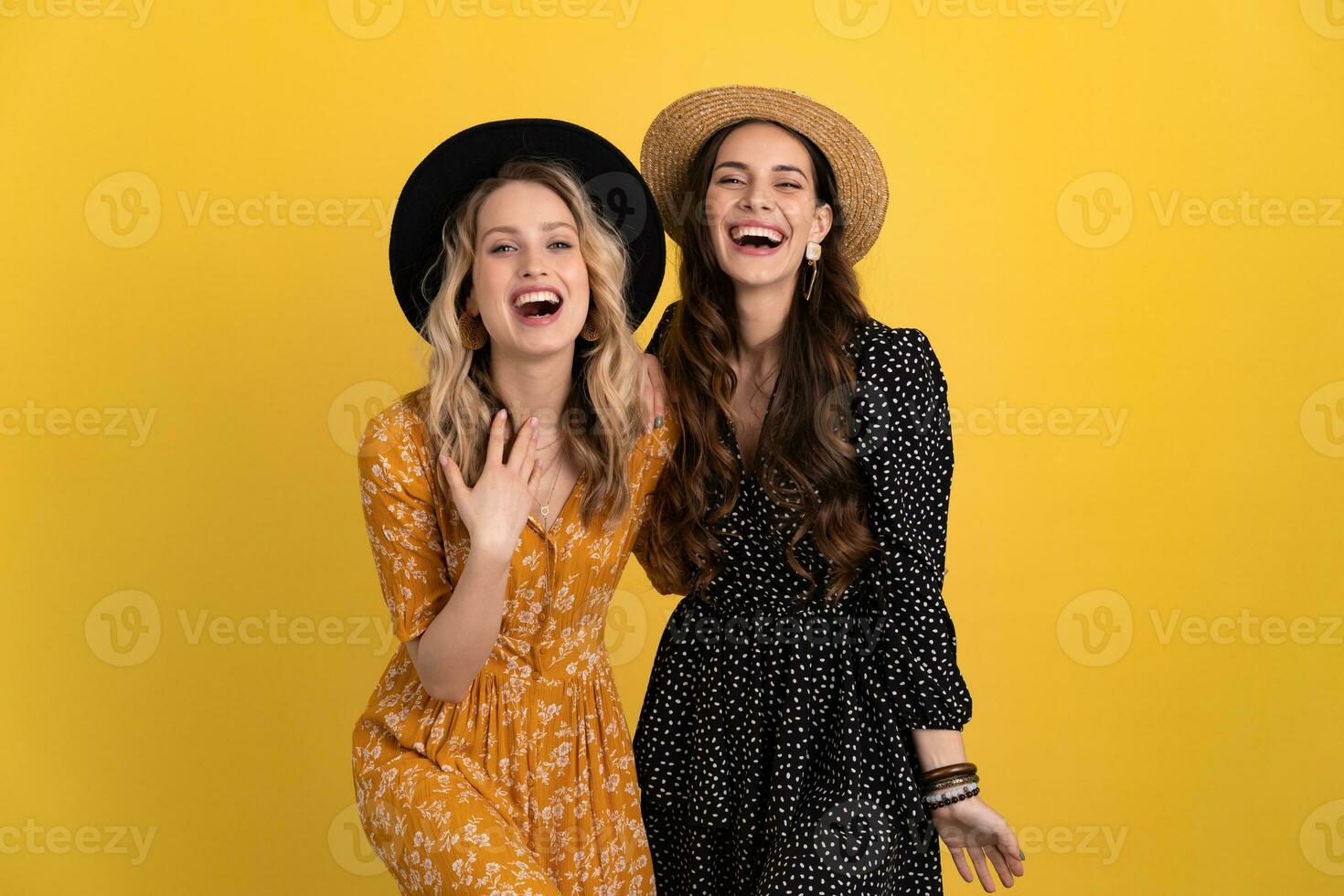 lindo mulheres amigos juntos isolado em amarelo fundo dentro Preto e amarelo vestir e chapéu foto