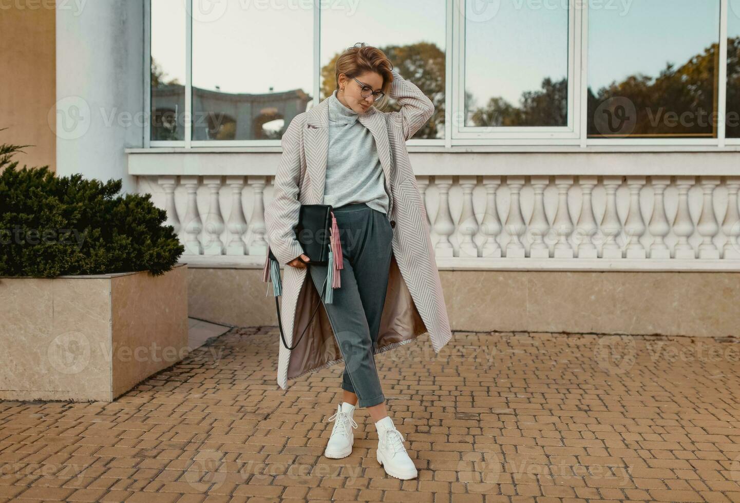 à moda elegante mulher caminhando dentro rua dentro elegante estilo casaco foto