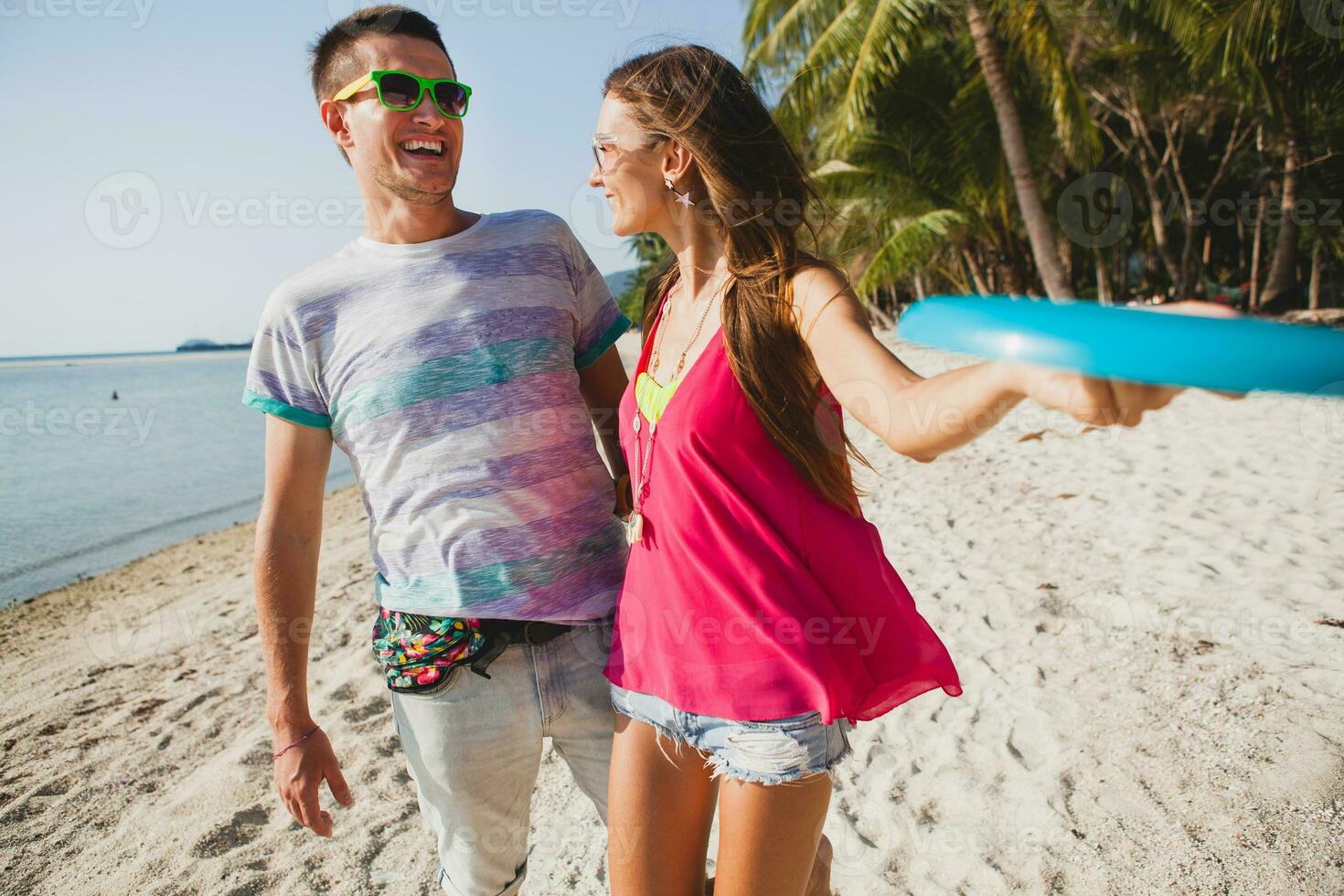 jovem casal homem e mulher jogando vôo disco em tropical praia, verão período de férias foto