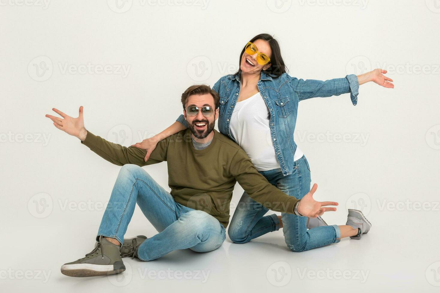 à moda casal sentado em chão dentro jeans foto