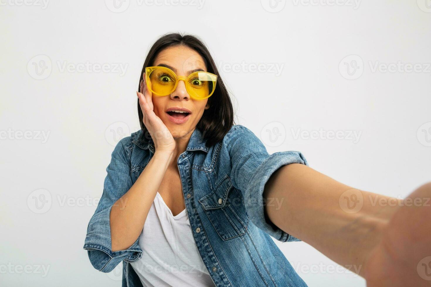 atraente mulher vestido jeans e jeans camisa vestindo amarelo oculos de sol foto