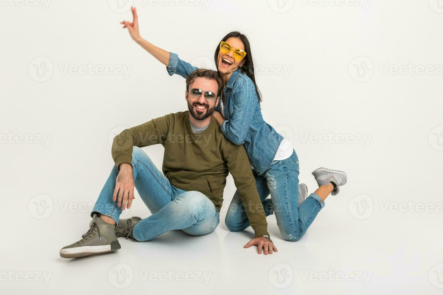 à moda casal sentado em chão dentro jeans foto