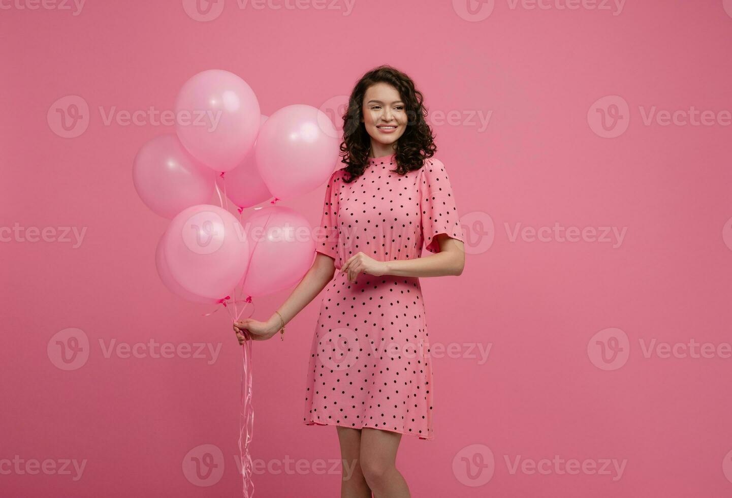 bonita jovem mulher posando isolado em Rosa estúdio fundo com Rosa ar balões foto