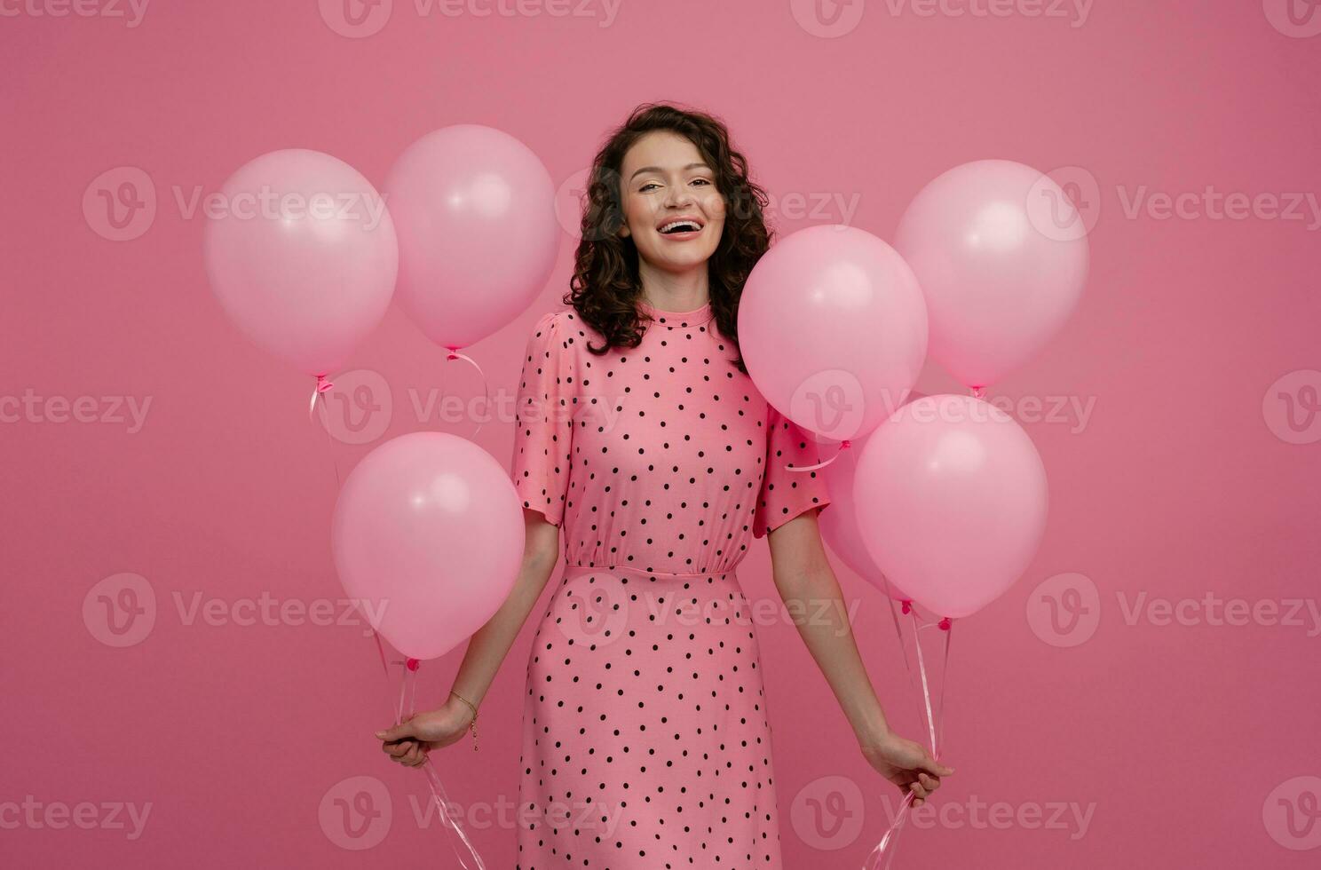 bonita jovem mulher posando isolado em Rosa estúdio fundo com Rosa ar balões foto