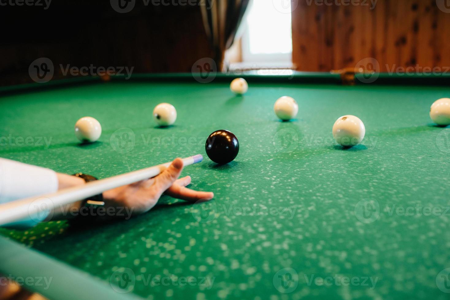 jovem elegante de terno escuro jogando bilhar foto