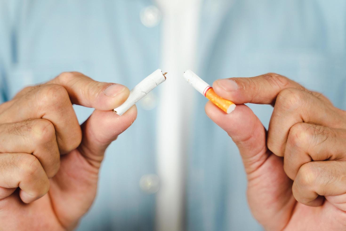 mão de homem esmagando cigarro, conceito de parar de fumar, mundo sem dia de tabaco. foto