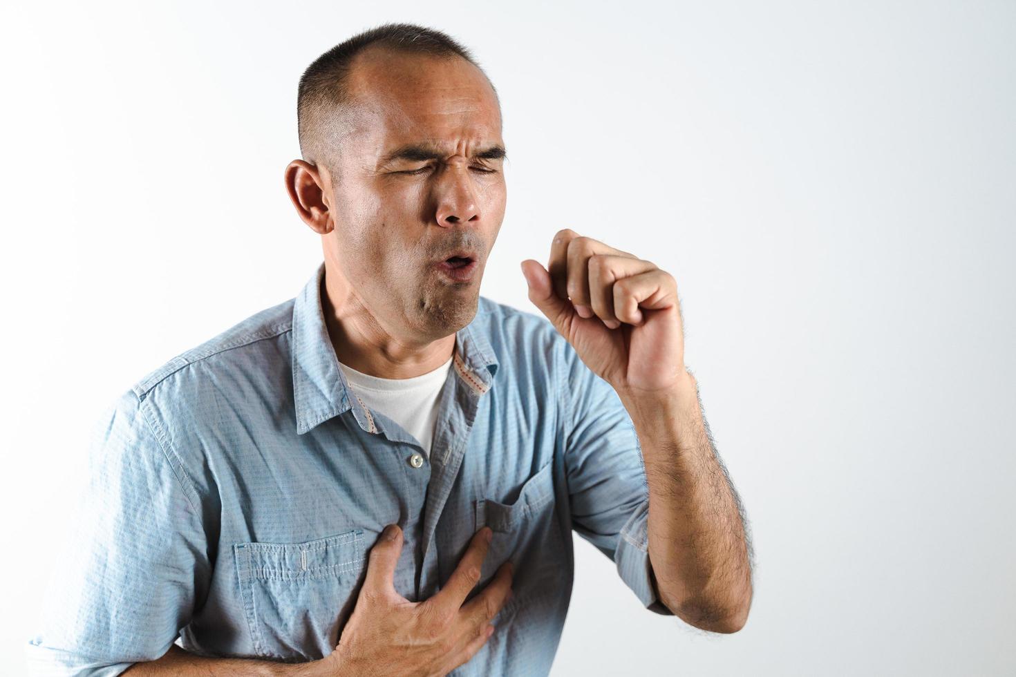 homem espirrando ou tossindo sobre a mão para evitar a propagação do vírus covid-19 ou vírus corona em fundo branco. foto