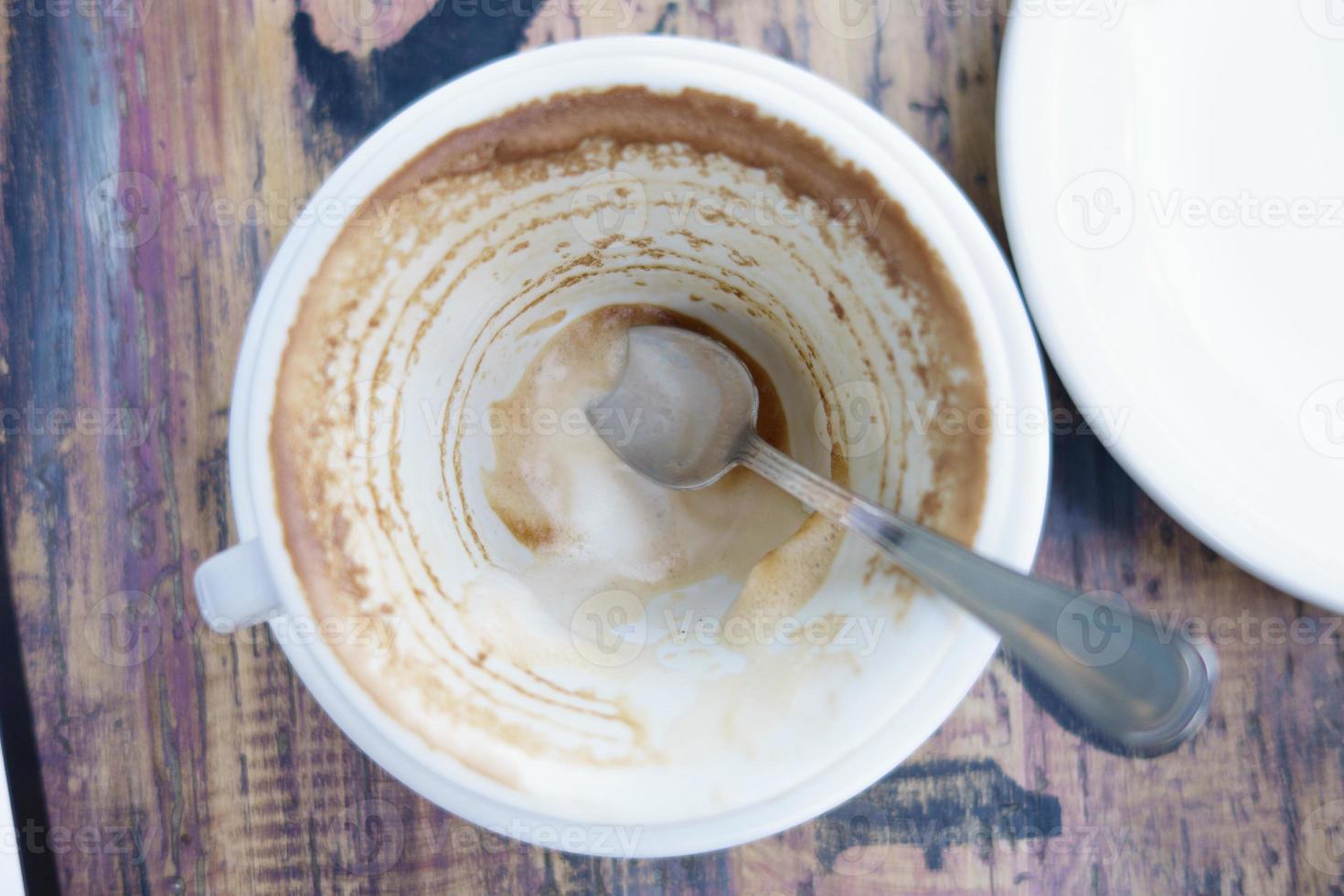 copo branco com sobras de café na mesa foto