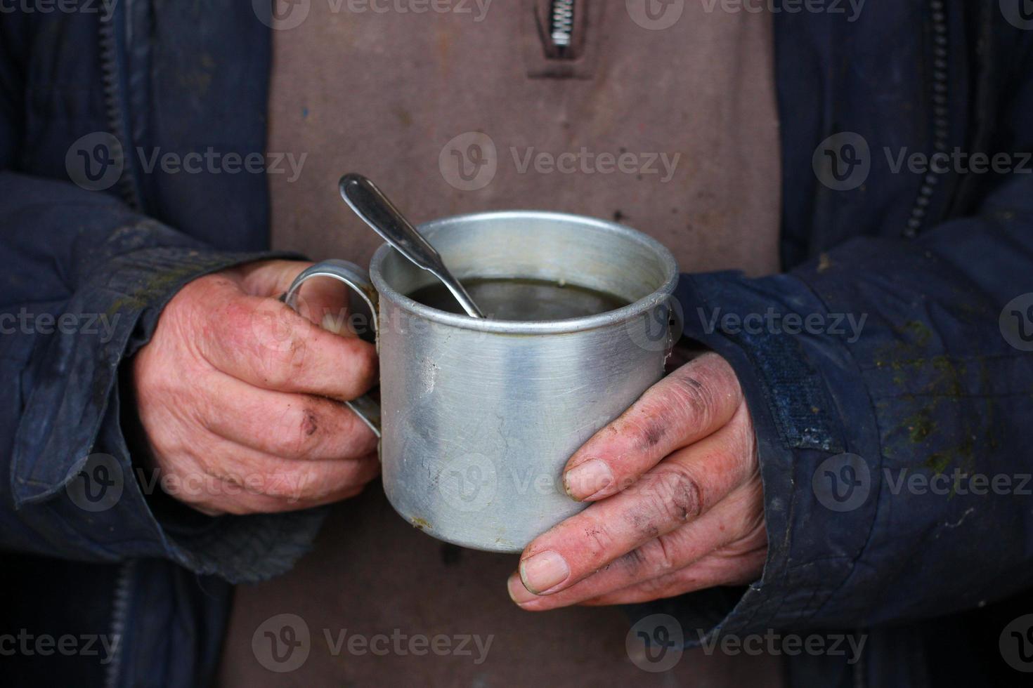 pobre homem segurando chá para se aquecer no inverno. foto