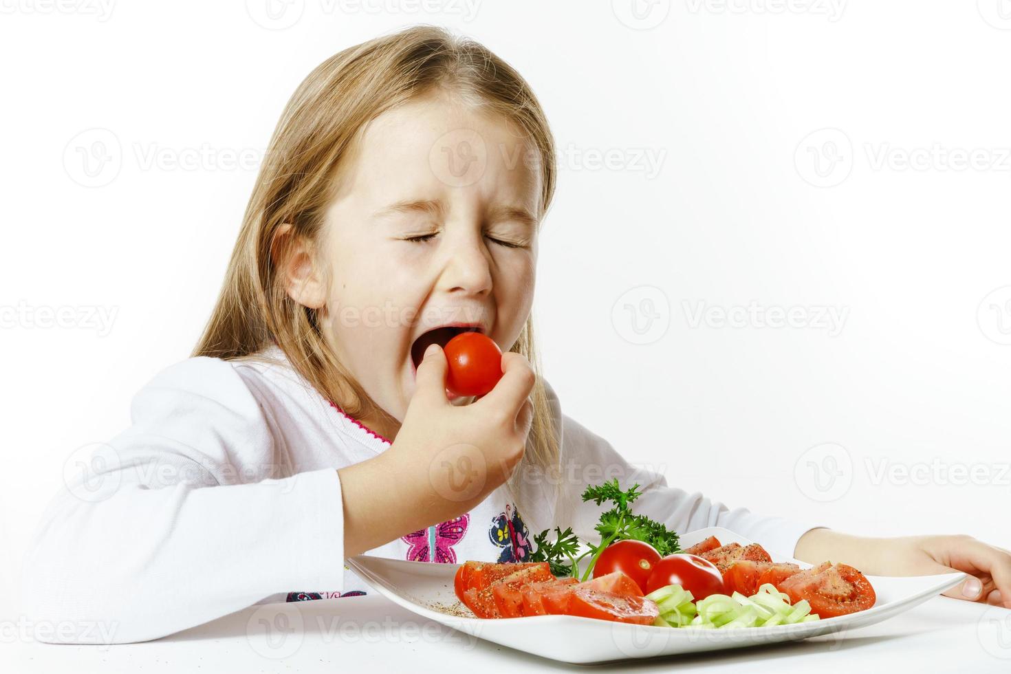 menina bonitinha com prato de legumes frescos foto