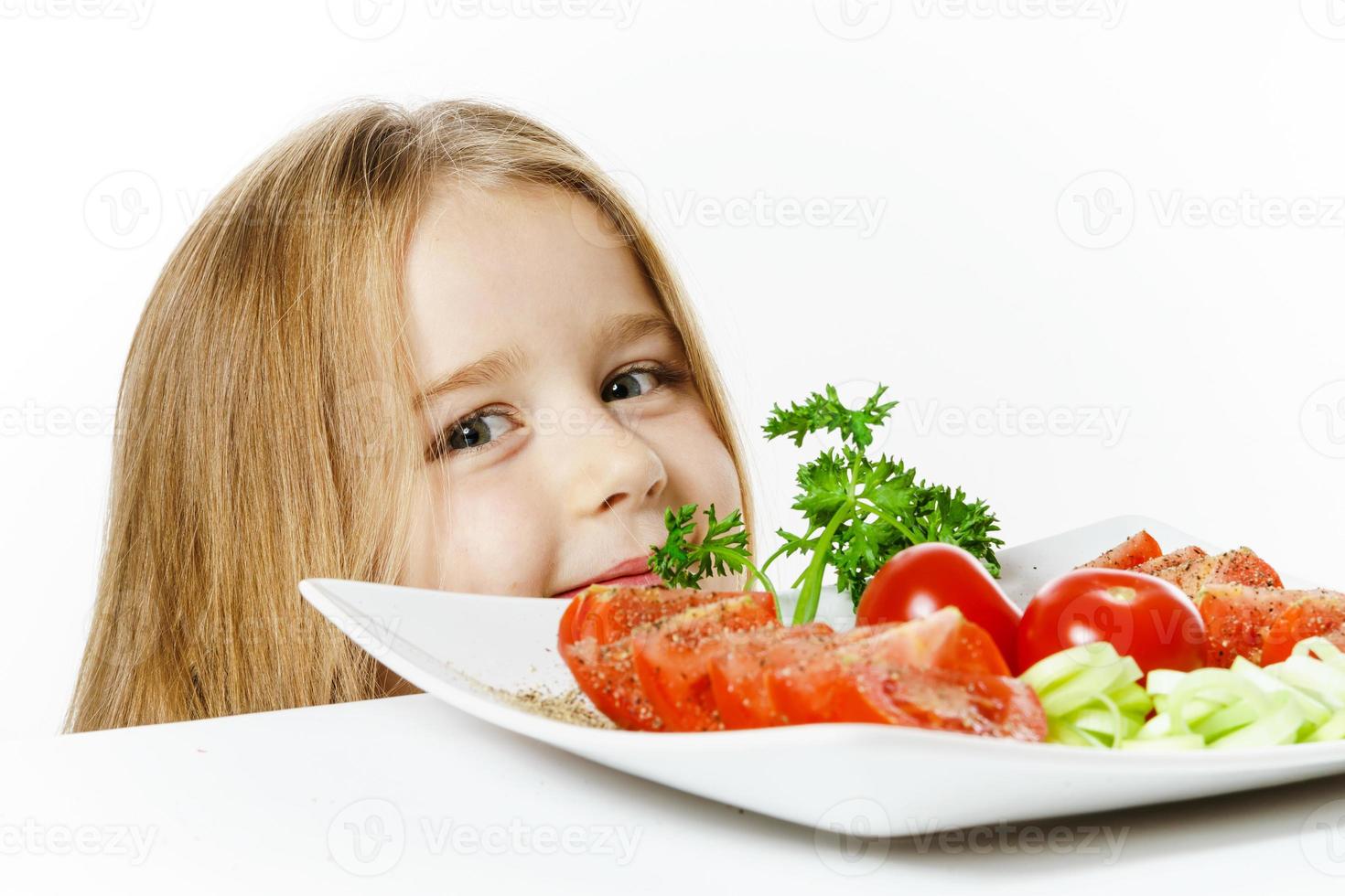 menina bonitinha com prato de legumes frescos foto