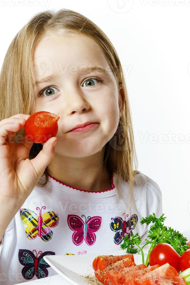 menina bonitinha com prato de legumes frescos foto