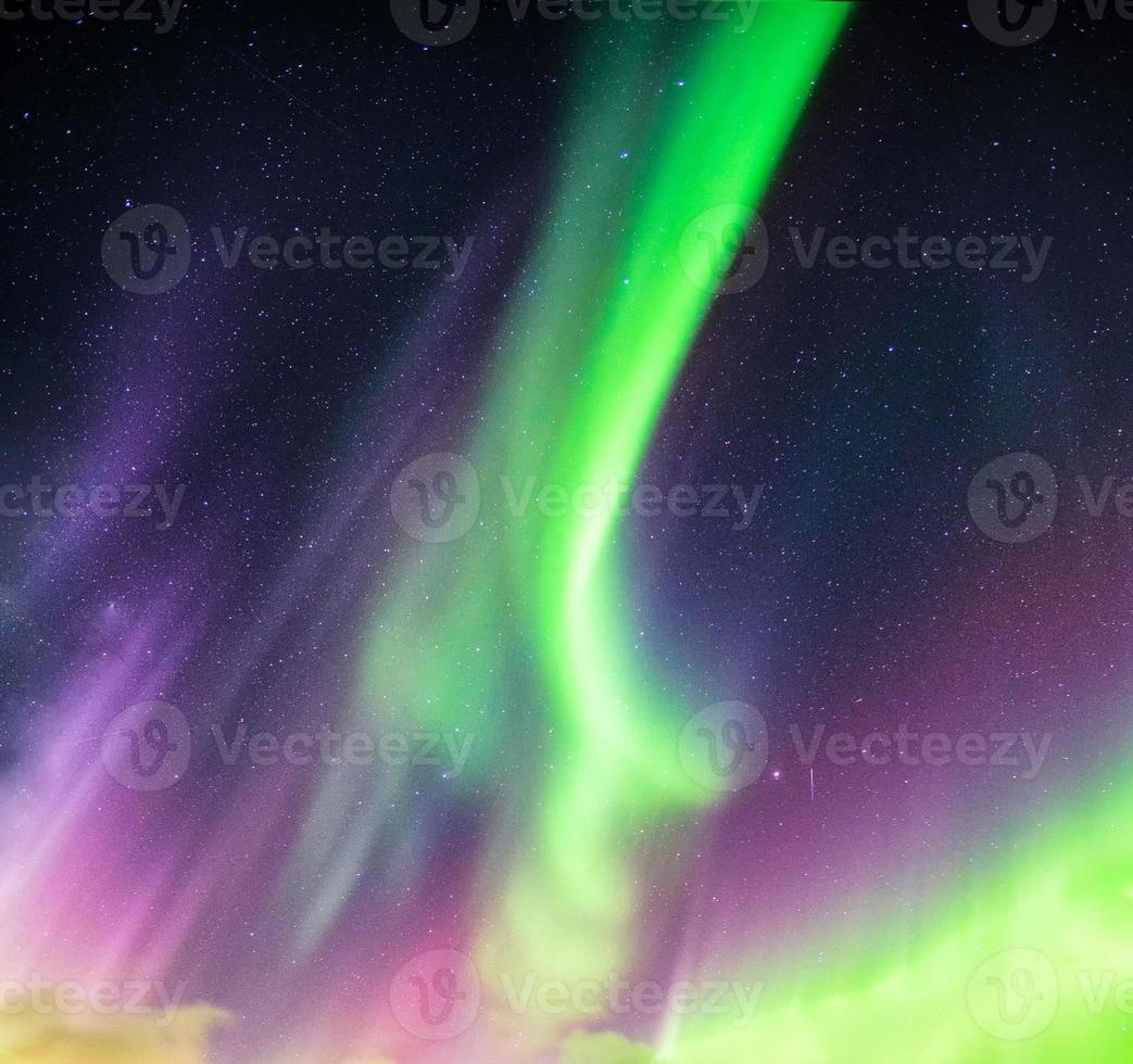 aurora boreal ou aurora boreal verde e roxa com estrelas no céu noturno foto