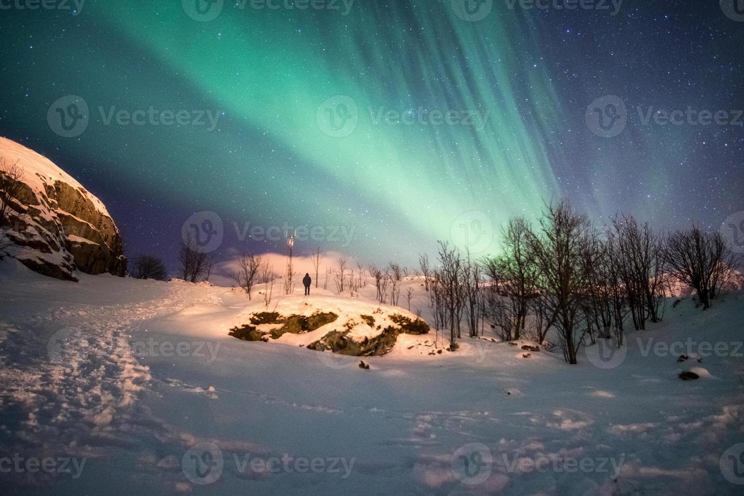 paisagem de montanha de neve com explosão de aurora boreal foto