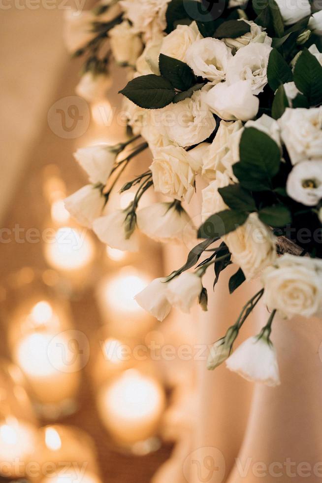 o presidium dos noivos no salão de banquetes do restaurante é decorado com velas e plantas verdes foto