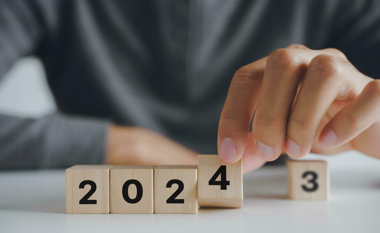 homem mão colocando de madeira cubo quadra para mudança 2023 ano para 2024 ano. começar para ano 2024. feliz Novo anos conceito. foto