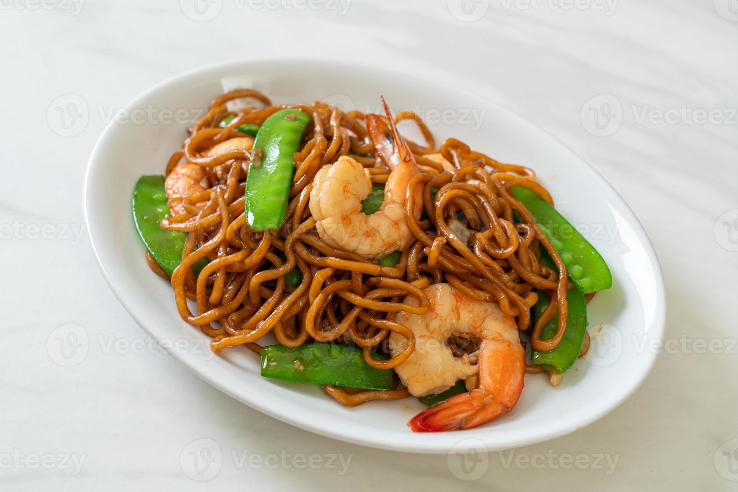 macarrão yakisoba frito com ervilhas e camarões - comida asiática foto