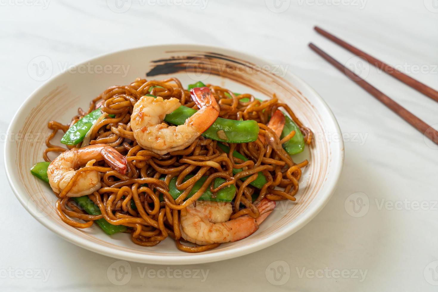 macarrão yakisoba frito com ervilhas e camarões - comida asiática foto