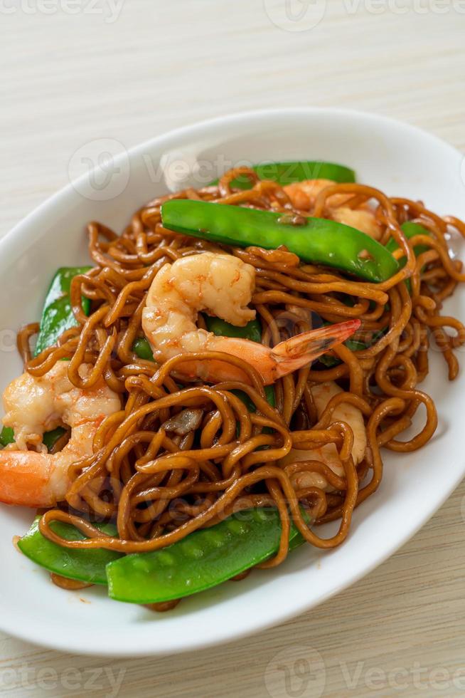 macarrão yakisoba frito com ervilhas e camarões - comida asiática foto