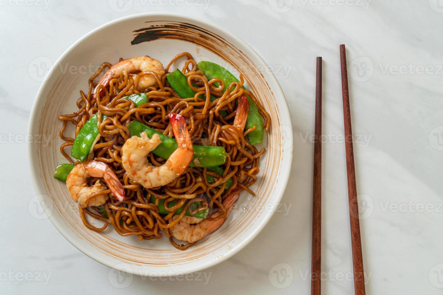 macarrão yakisoba frito com ervilhas e camarões - comida asiática foto