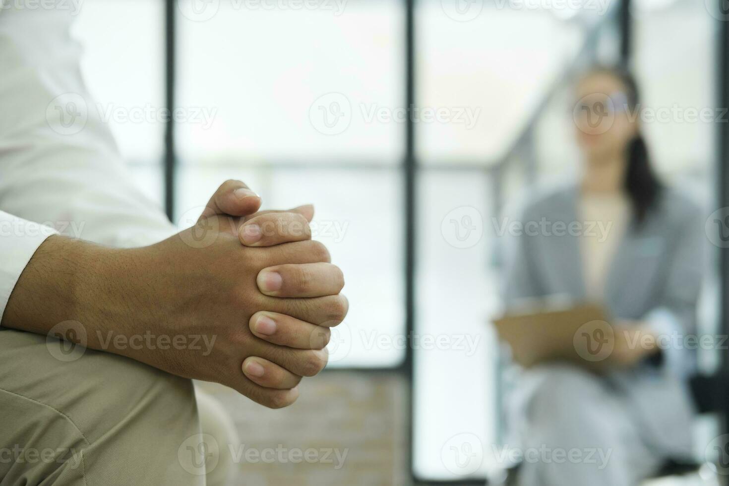 fechar acima do homem mãos cerrado dentro estresse enquanto discutindo dele estresse, ansiedade, e problemas com uma psiquiatra ou terapeuta às a clínica. foto