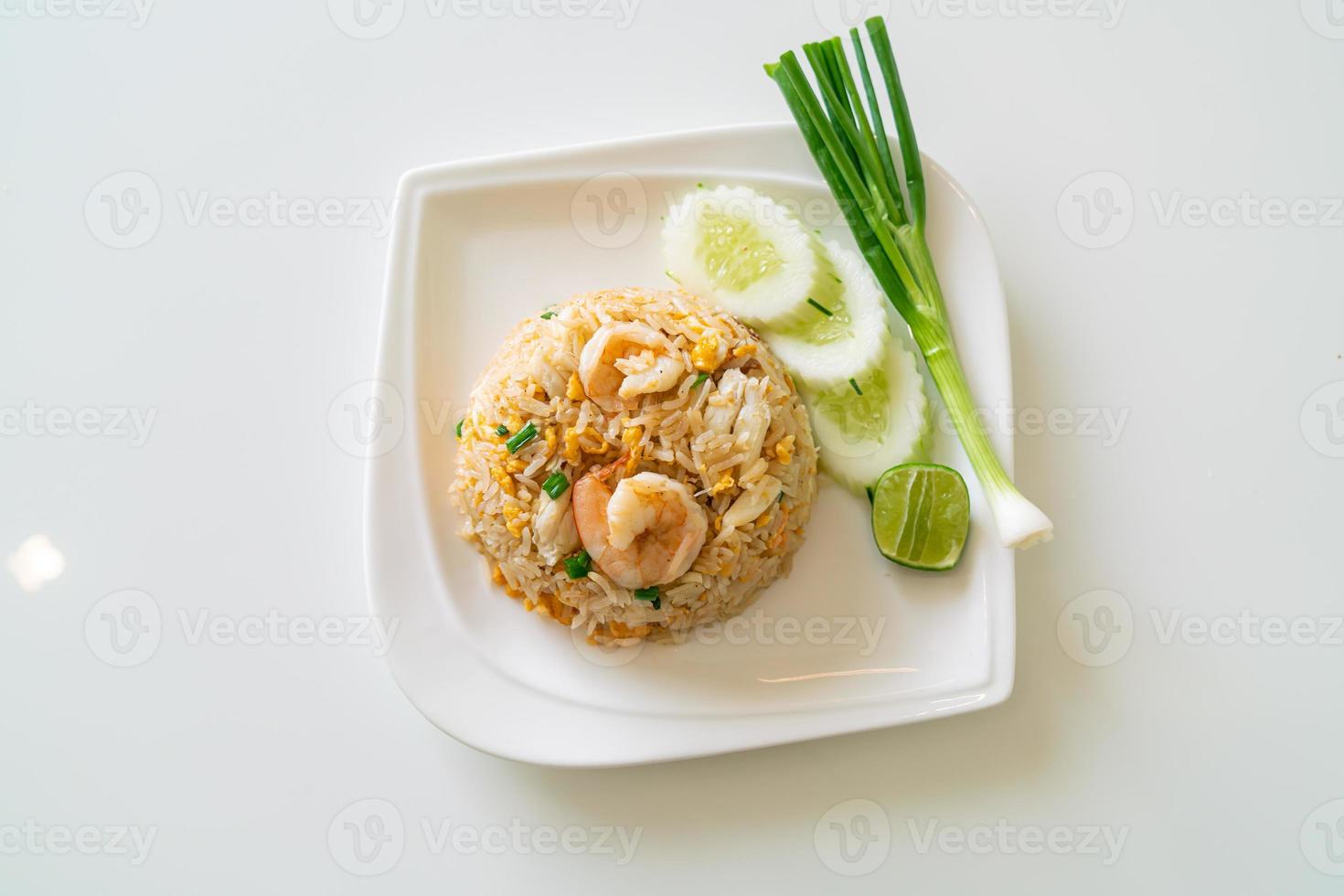 arroz frito com camarão e caranguejo no prato branco foto